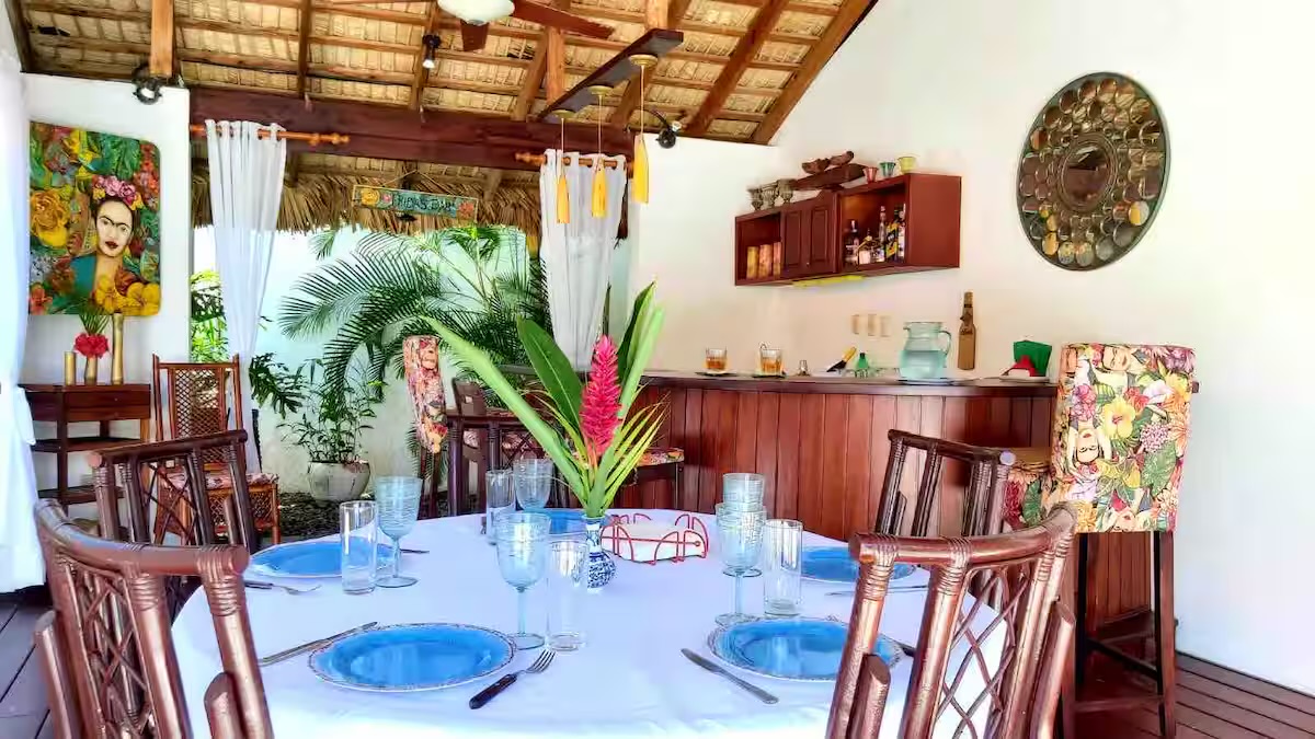 Open-air dining under a thatched roof set for a group meal