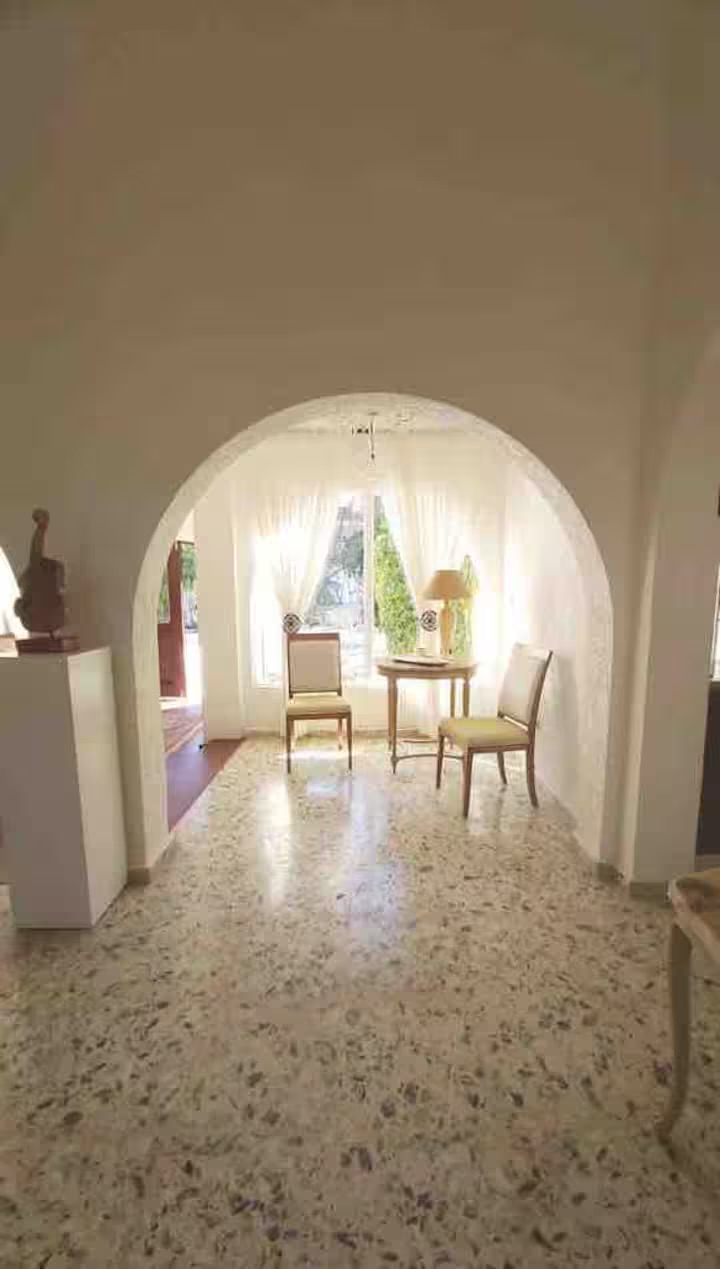 Vaulted-ceiling hall with arched entry and terrazzo floors