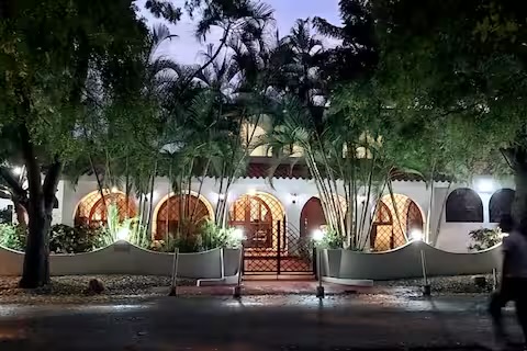 The villa exterior glowing at dusk, framed by palms